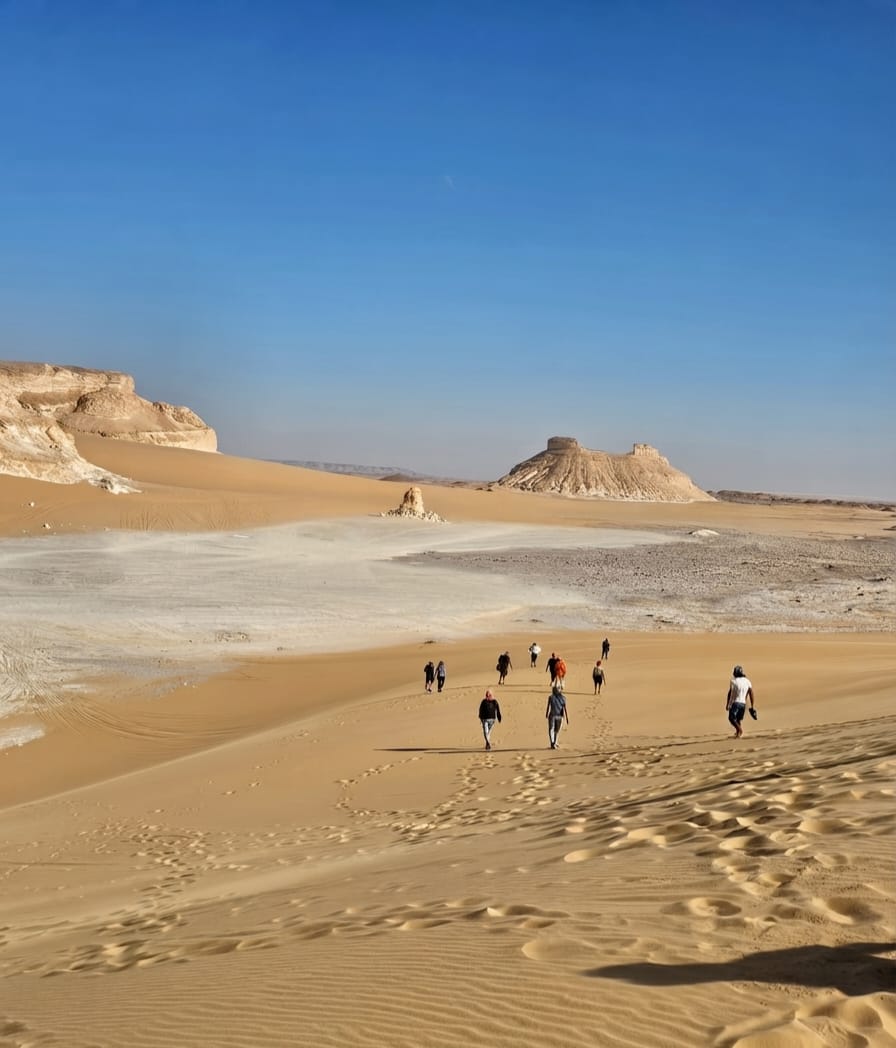 Group of trekkers hiking through the White Desert landscape, Egypt
