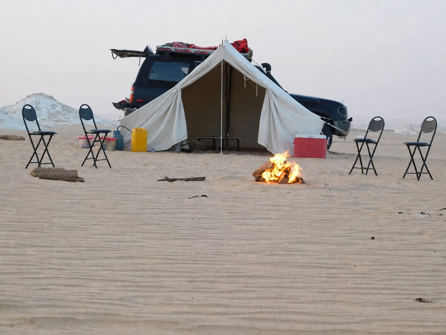 Desert camping setup with tent and campfire in Egypt's White Desert